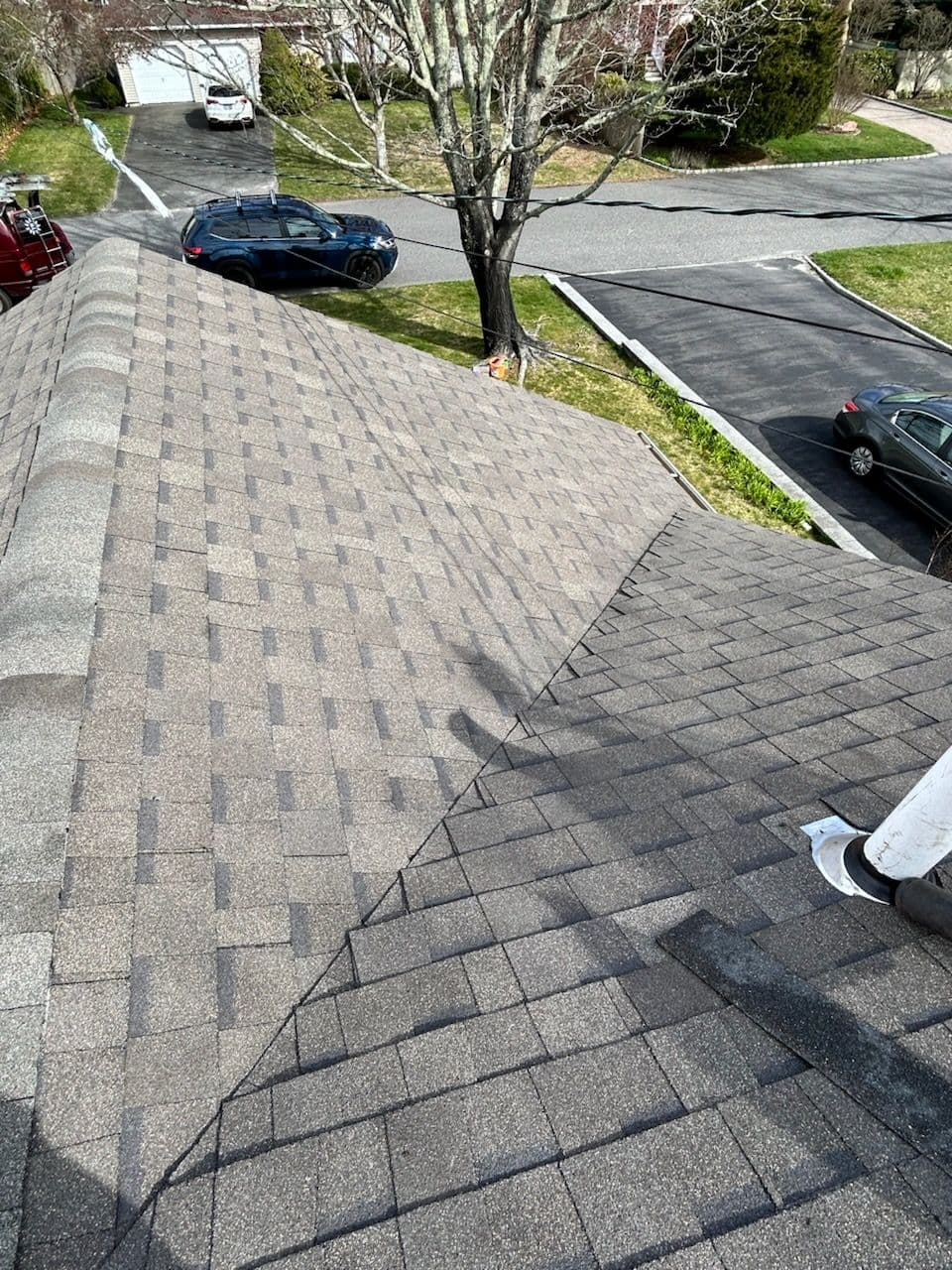 Aerial view of a gray shingle roof with asphalt shingles on a residential home.