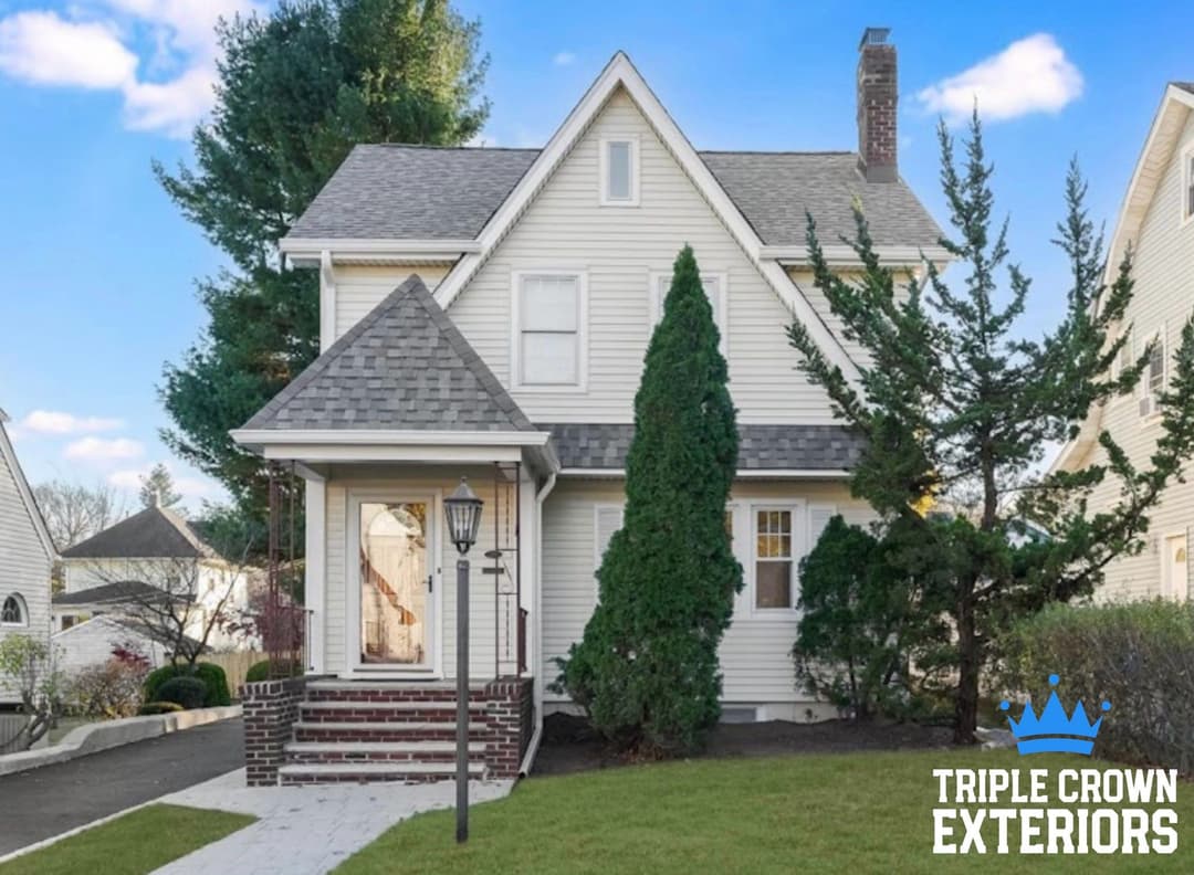 Victorian-style home with landscaped front yard and inviting porch, by Triple Crown Exteriors.