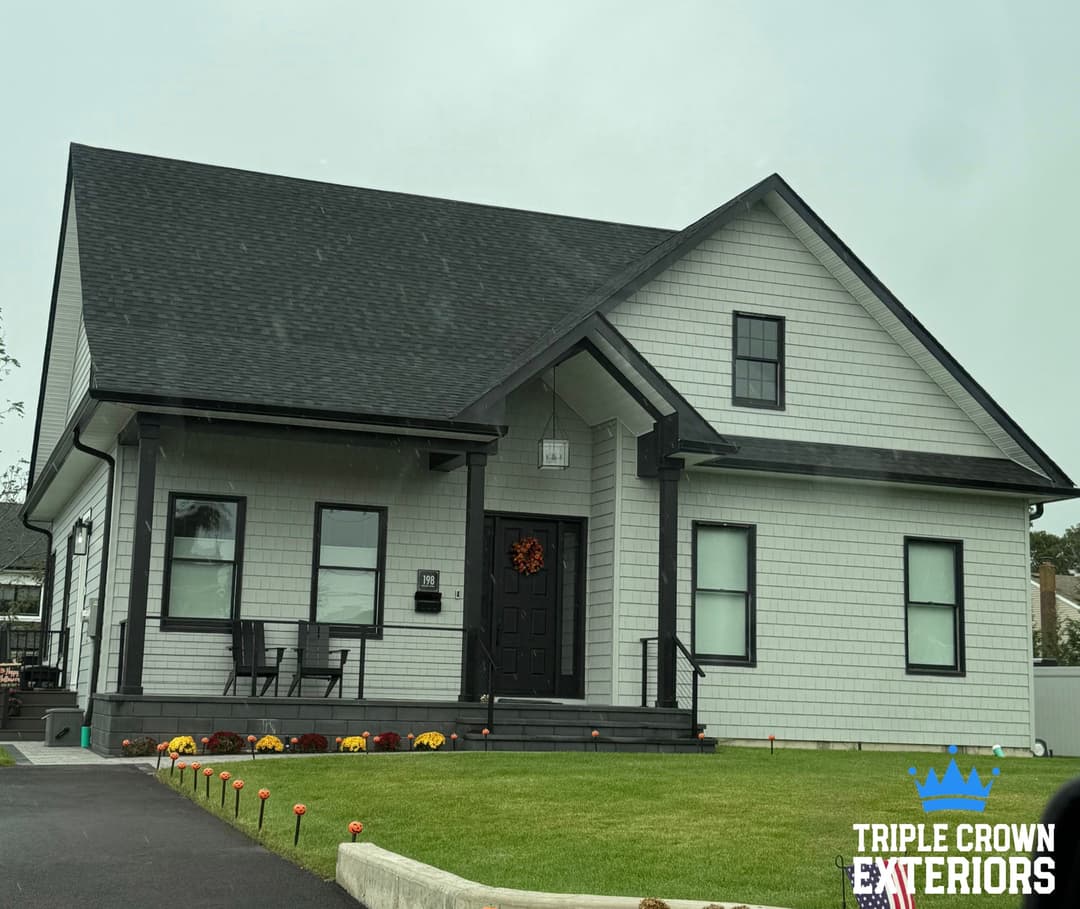 Modern two-story house with dark roof, white siding, and decorative autumn wreath.